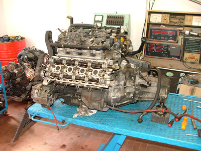 Motore in fase di smontaggio. Sullo sfondo il motore di una delle Thema turbo 16v seconda serie di Emi.